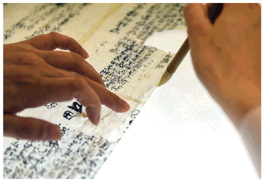 ▲5月17日，在安徽博物院文物科技保护中心纸质文物修复室，工作人员对古籍文物进行补全。新华社记者周牧摄