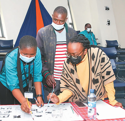 4月8日,肯尼亚国家图书馆举办中国文化体验活动。图为人们在练习写汉字。新华社记者 龙 雷摄