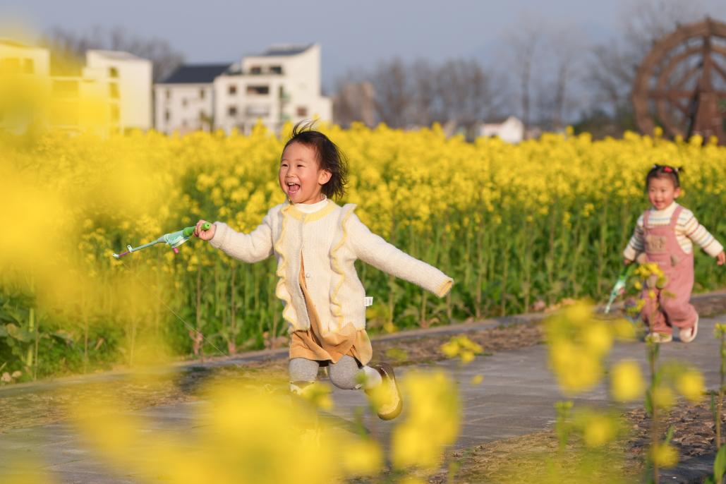 3月11日,小朋友在桐庐县梅蓉村油菜花田间奔跑、玩耍。 新华社记者 黄宗治 摄