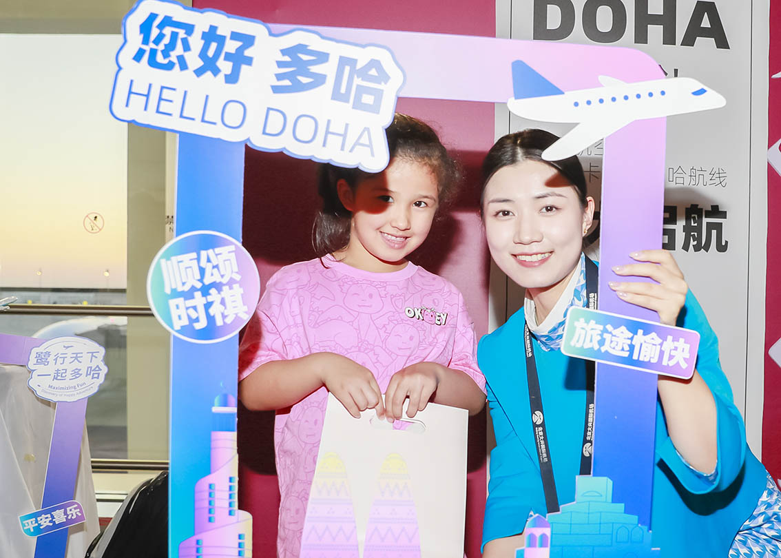 2023年10月20日，乘客和空乘人员在厦门航空北京-多哈航线首航现场合影（新华社发）