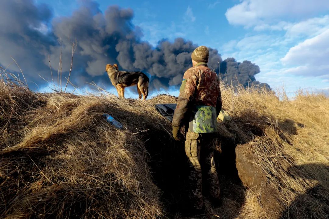 2月27日，乌克兰基辅附近，乌克兰人所眺望的方向是一处石油储存库，在遭导弹袭击后冒出了浓烟。图/澎湃影像