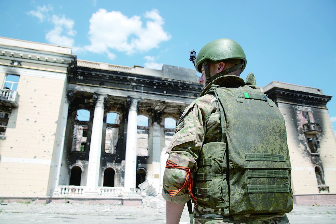 7月3日，一名俄军人站在利西昌斯克受损的建筑旁。（视觉中国）
