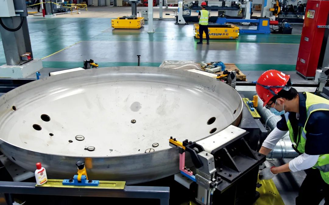 2021年6月2日，江苏连云港经济技术开发区的连云港中远海运特种装备制造有限公司生产车间，工人正在安装、调试LNG罐箱智能生产线。图/中新