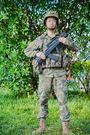 穿着绿色衣服的男人站在树下  低可信度描述已自动生成