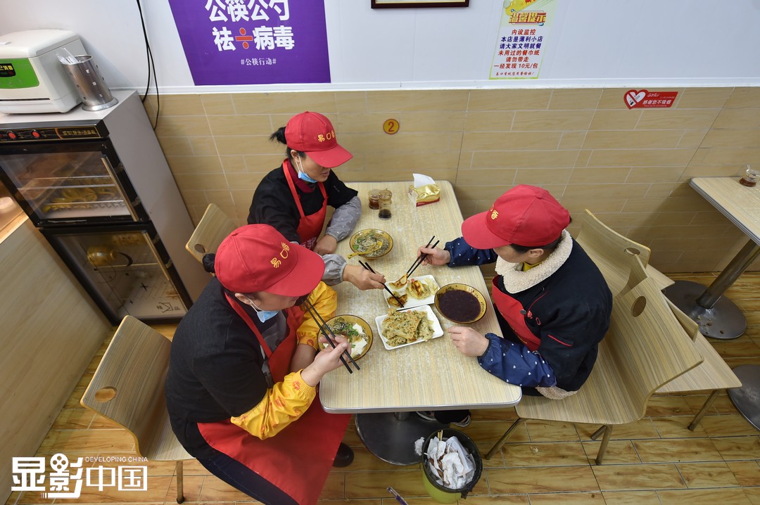 11月21日，将近中午，王素侠（中）才和同事们坐下来吃早餐。新华网发（杨晓原 摄）