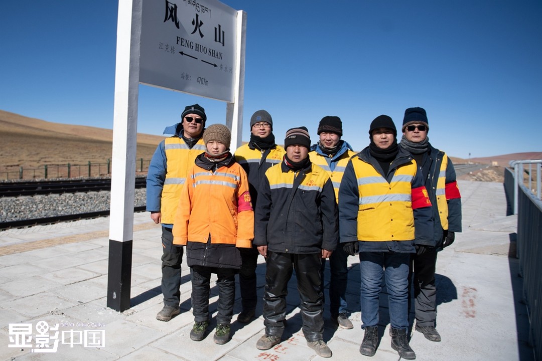 鄂年明（右二）和工友在海拔4707米的风火山车站合影留念。