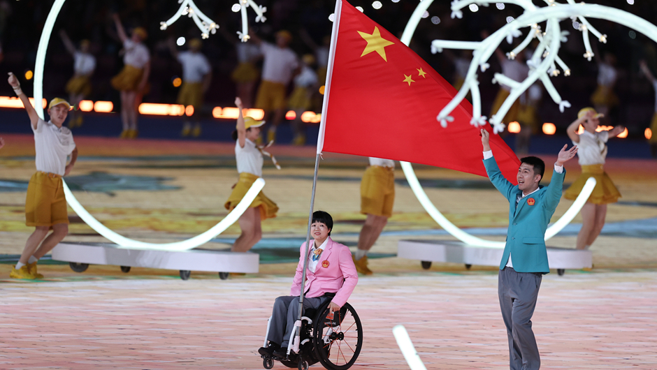 中国代表团旗手黄晓连（左）与孙刚在开幕式上入场