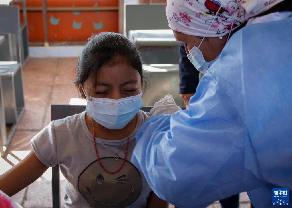 10月18日，医务人员在厄瓜多尔首都基多一所学校为学生接种疫苗。新华社发