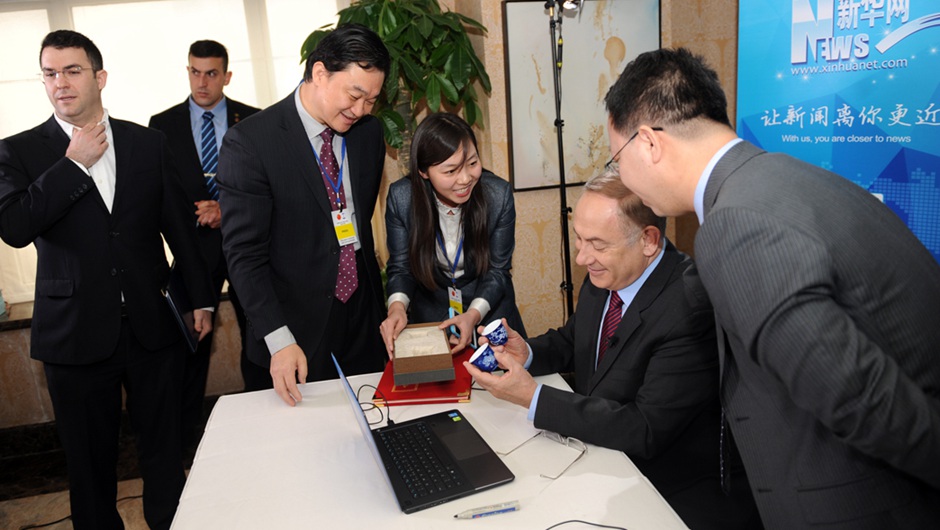 新华网董事长、总裁田舒斌向以色列总理内塔尼亚胡赠送新华网上市纪念对杯