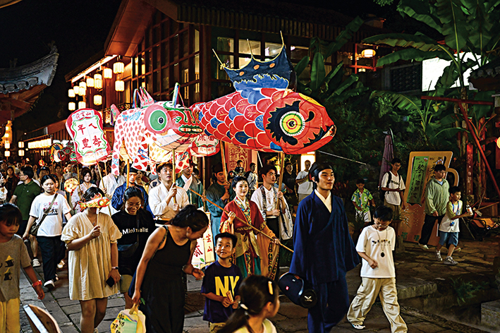 2025年8月27日,在黄山市休宁县齐云山生态文化旅游度假区,游客们观赏非遗鱼灯巡游 周牧摄/本刊 2025年8月27日,在黄山市休宁县齐云山生态文化旅游度假区,游客们观赏非遗鱼灯巡游 周牧摄/本刊